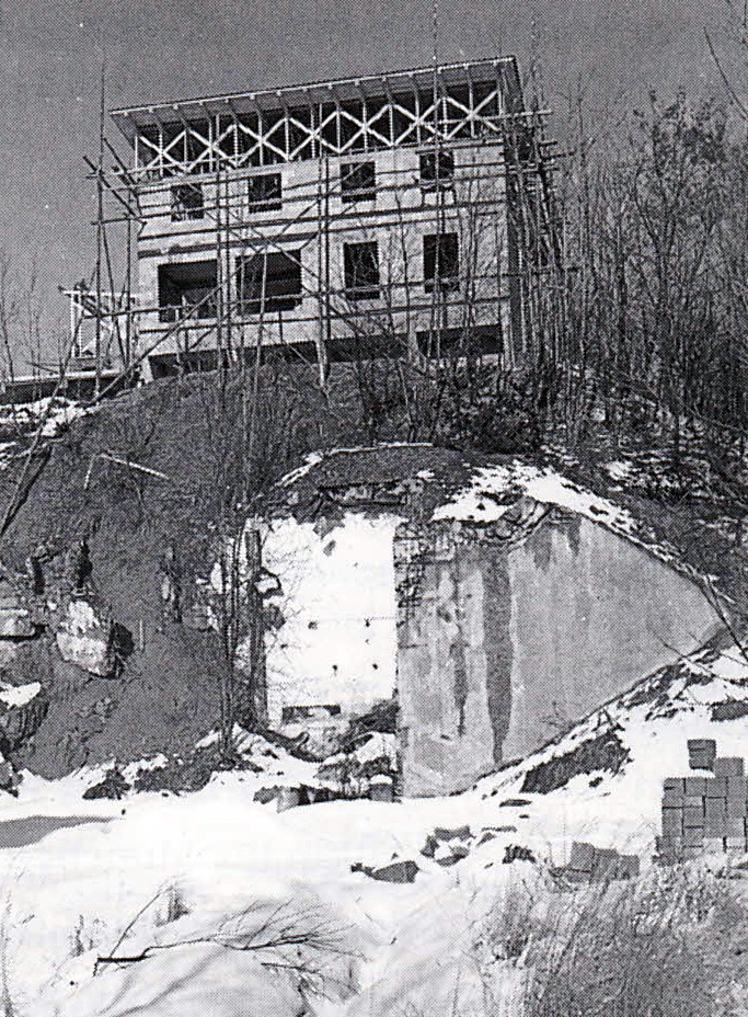 Rohbau mit Bunkerruine im Vordergrund